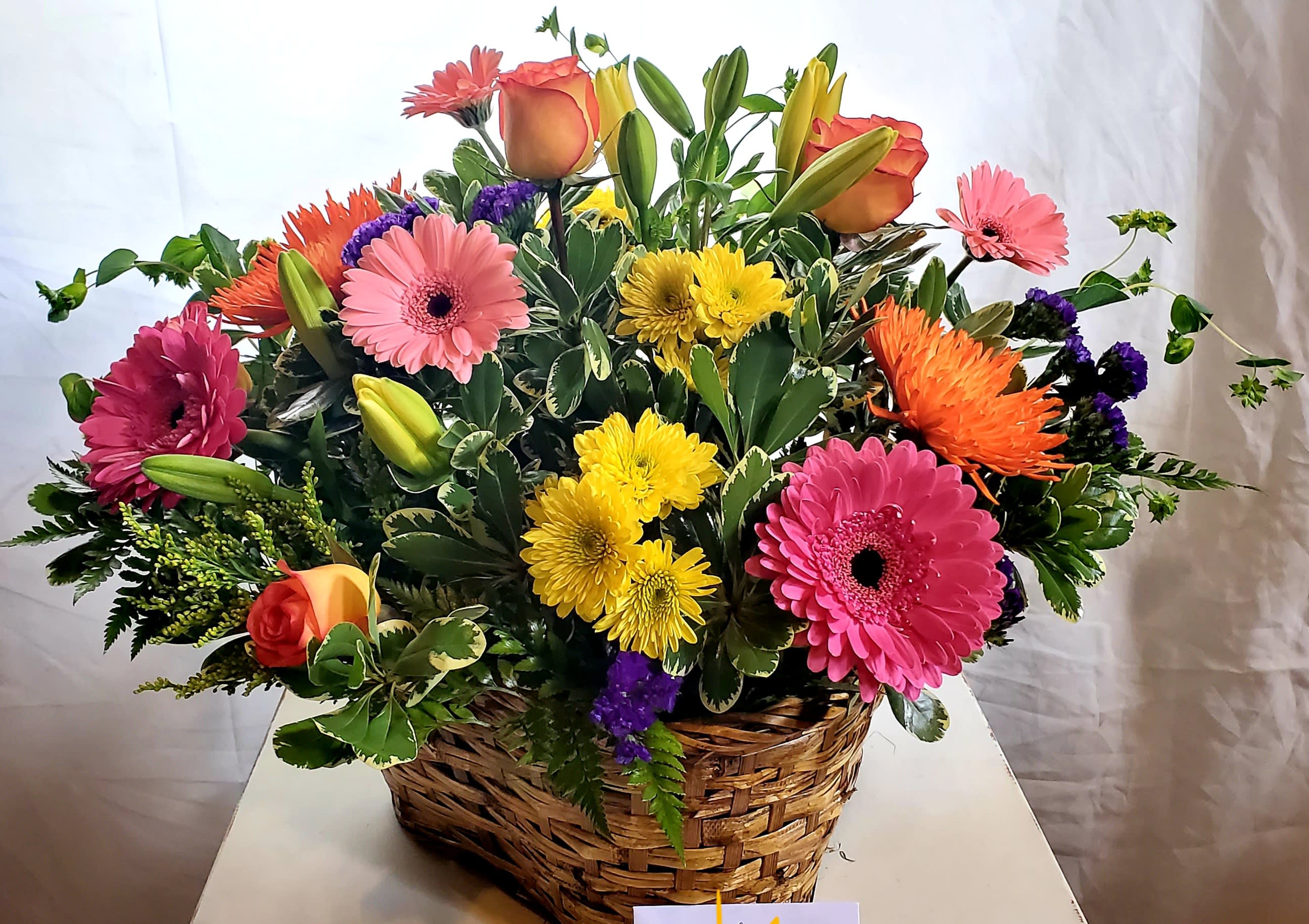 Bright Beauty - An elegant bright basket for any occasion.  Enjoy seasonal blooms in a delightful wicker basket.