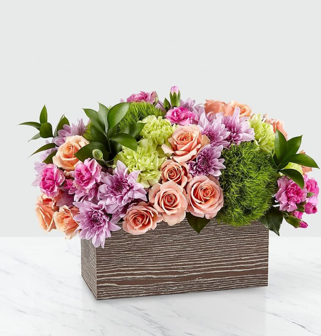 Simple Charm - Capture the beauty of the seasons in bloom with our Simple Charm Bouquet. Gorgeous blooms such as peach spray roses, green trick dianthus, pink mini carnations and lavender cushion pompons fill a weathered wooden box with freshness. Whether you're saying thank you to a special friend or sharing the most heartfelt get-well message, this arrangement is a breathtaking gift for your loved ones to cherish. - GOOD bouquet is approximately 8&quot;H x 13&quot;W - BETTER bouquet is approximately 9&quot;H x 14&quot;W - BEST bouquet is approximately 10&quot;H x 15&quot;W