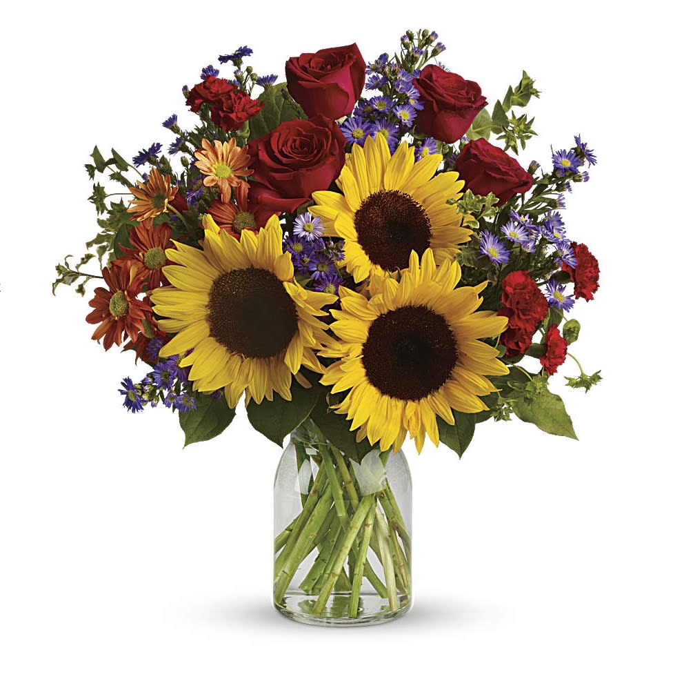 Pure Happiness - A sunny sunflower bouquet gets an autumnal spin with the addition of pretty bronze daisy mums and rich red roses. The cheerful autumn floral arrangement is rich with color, making it a stylish, energizing pick for any fall occasion.