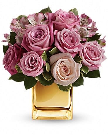 A Radiant Romance by Teleflora - Ravishing roses and a radiant cube vase combine to stunning effect in this amazing arrangement featuring soft, romantic shades of pink and lavender. It's sure to make her heart radiate with love and affection! This bouquet is rich in roses and alstroemeria in soft shades of pink and lavender -variegated pittosporum gives texture and greenery. Delivered in a golden mirrored cube vase to add a luxurious touch. 
