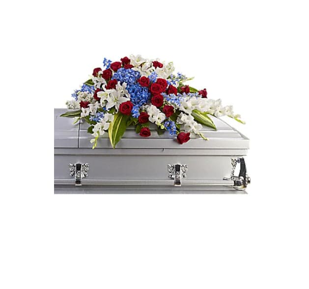 Distinguished Service Casket Spray - &quot;A beautifully patriotic way to pay tribute to a loved one. This half-couch spray sends an eloquent message of strength, respect and freedom. Brilliant flowers such as blue hydrangea, red roses, white oriental lilies and much more create this dignified way to honor the deceased.   Orientation : One-Sided  All prices in USD ($)  Standard  T240-3A&quot;