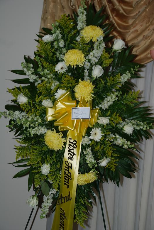 Yellow Standing Spray - Yellow standing spray with yellow hydrangeas, white daisies, white roses, and tropical leaves.