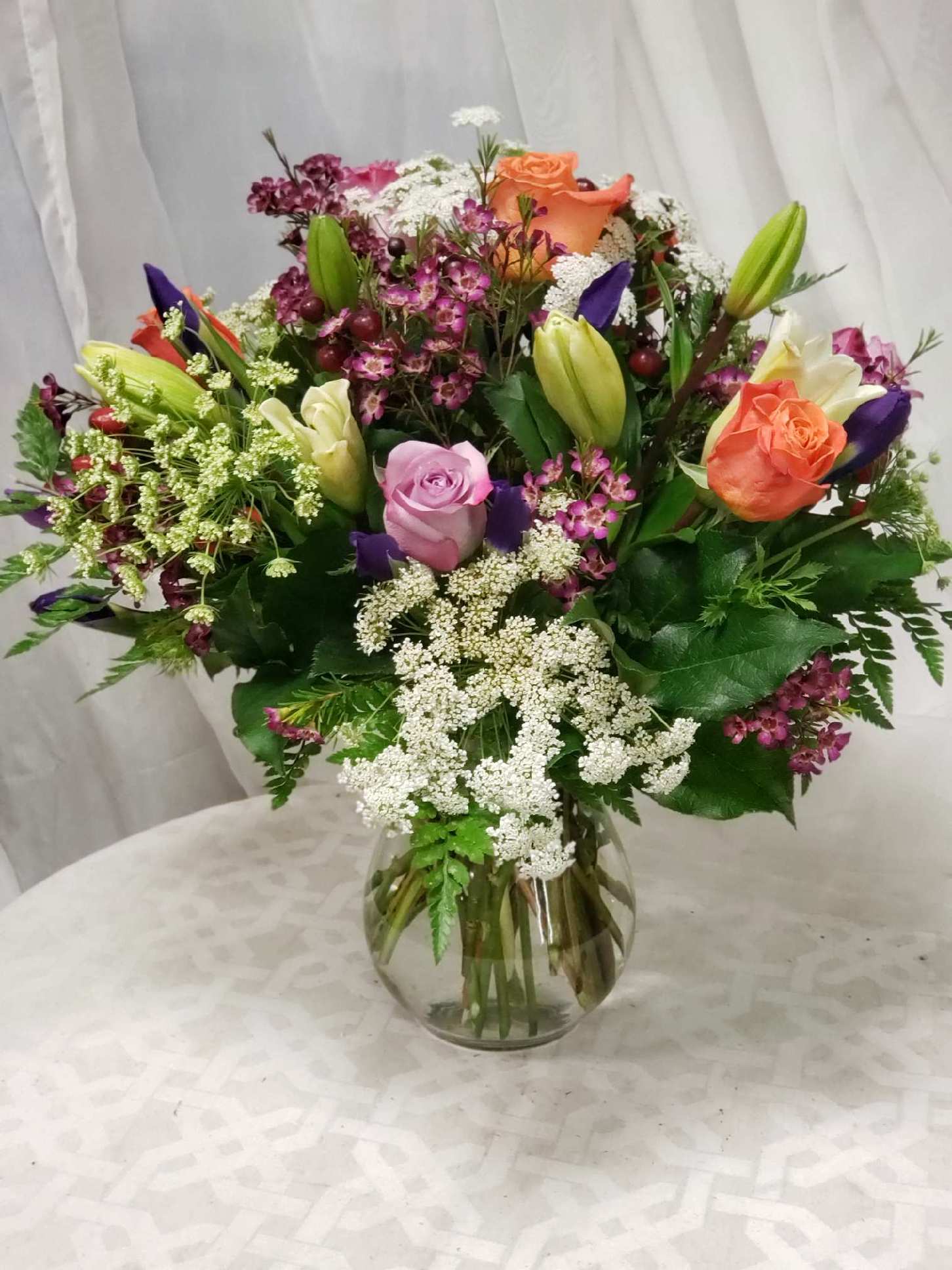 Sunset bouquet - Vase arrangement of Roses, lilies and other accents. 