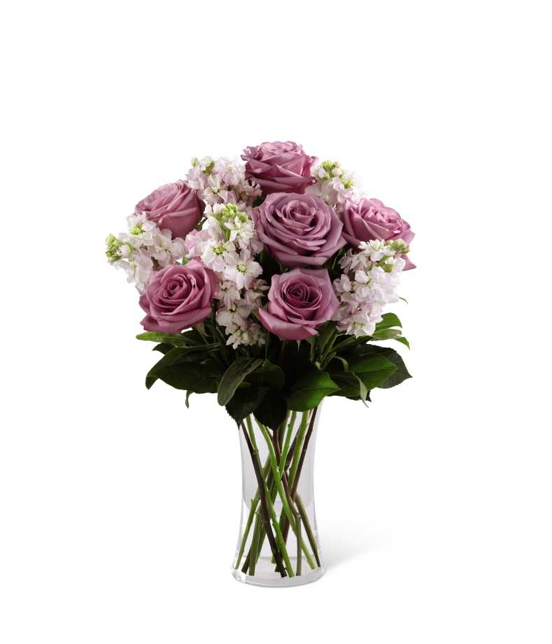 The FTD All Things Bright Bouquet - The FTD All Things Bright Bouquet offers warmth and comfort to your special recipient during this time of loss and grief. Gorgeous lavender roses are arranged amongst fragrant pink stock and lush greens, seated in a clear glass vase, to create a bouquet that beautifully conveys your deepest sympathies.