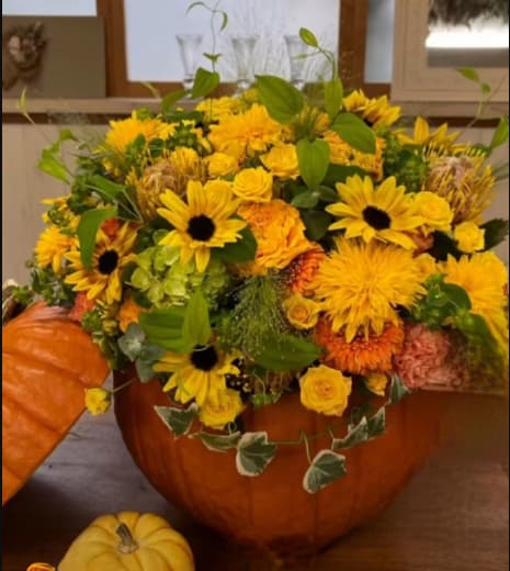 Vibrant pumpkin - Beautiful natural pumpkin, with beautiful sunflowers, daisies of vibrant colors and exquisite vegetation of the season, ideal arrangement for events or surprising your loved one.  Hermosa calabaza natural, con hermosos girasoles, margaritas de colores vibrantes y exquisita vegetación de temporada, arreglo ideal para eventos o sorprender a tu ser querido.