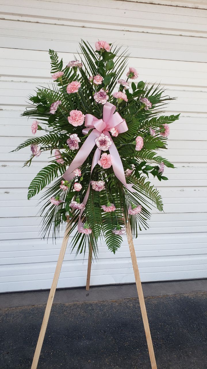 Pink Tribute. - Spray standing with 18  light pink carnation, 5 stems light pink mini carnation , Western sword fern and  Robeline leaves  with a nice pink bow. comes in wood easel.