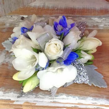 Sweet White Corsage - This corsage is on the rhinestone wristlet(it is a keepsake bracelet).  Sweet white blossoms with blossoms of blue delphinium and accented with silver - ribbon, leaves, etc.