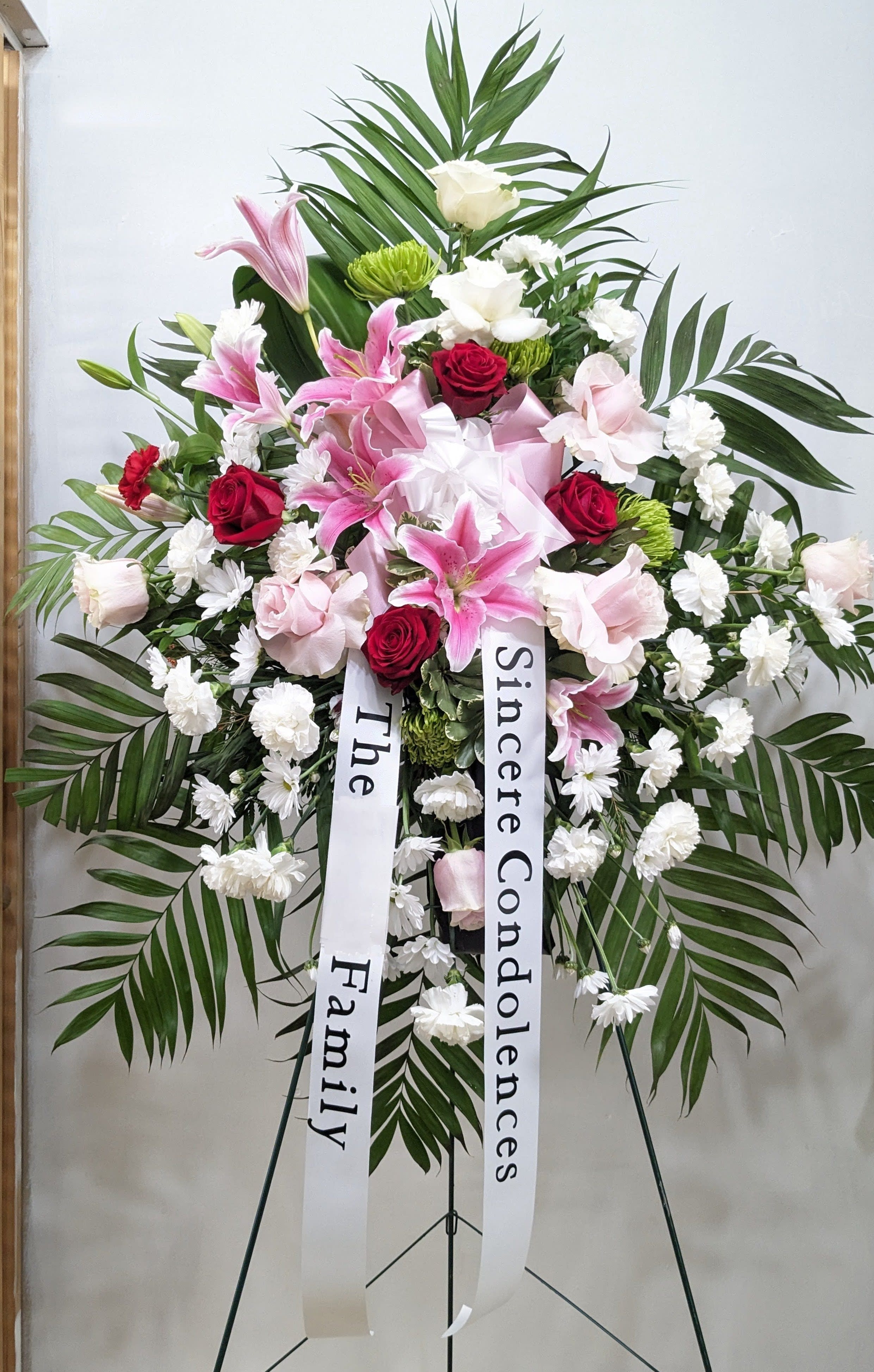 True Sympathy - An all white tribute, this funeral spray is pure and tranquil. Featuring a variety of white flowers and green palms this elegant funeral spray brings a feeling of peace to it's surroundings.
