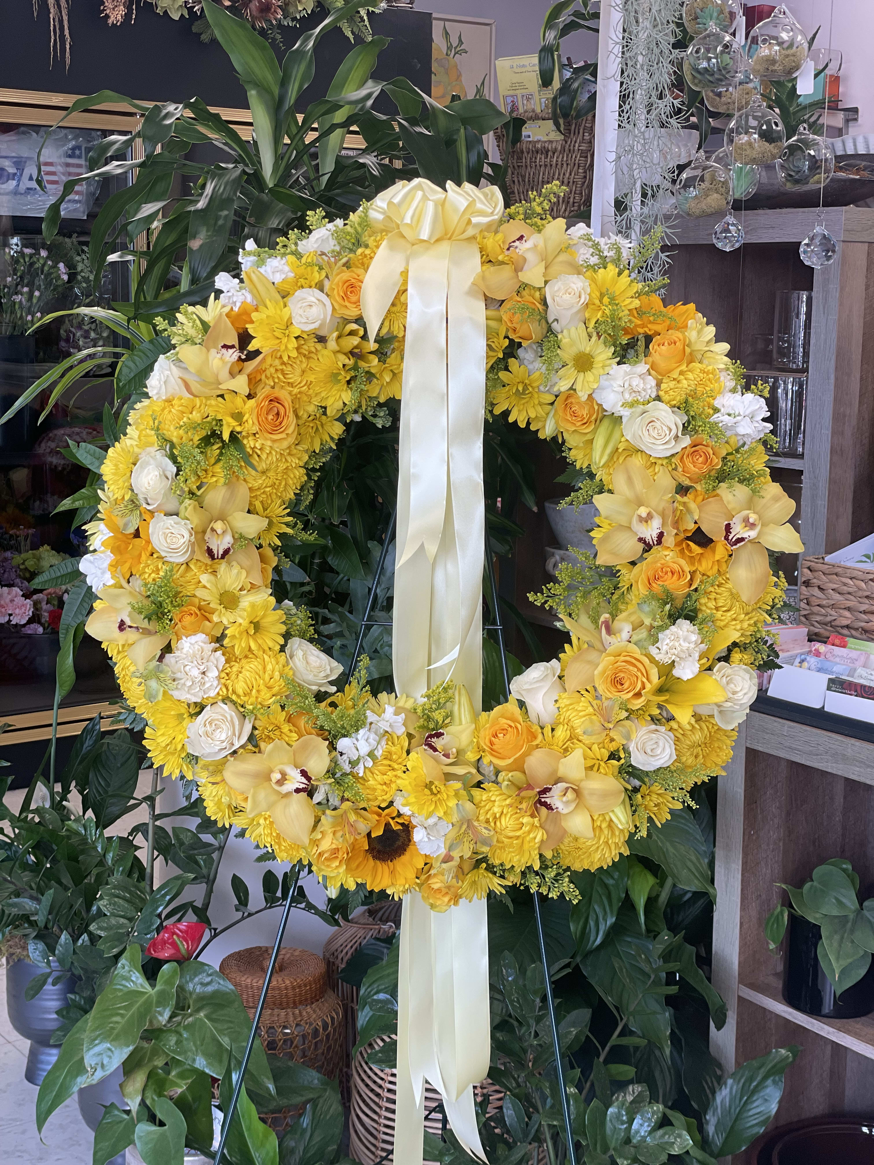 Eternal Sunset - A combination of yellow and white flowers such as roses, cymbidium orchids, sunflowers, daisy, carnations and solidago. 