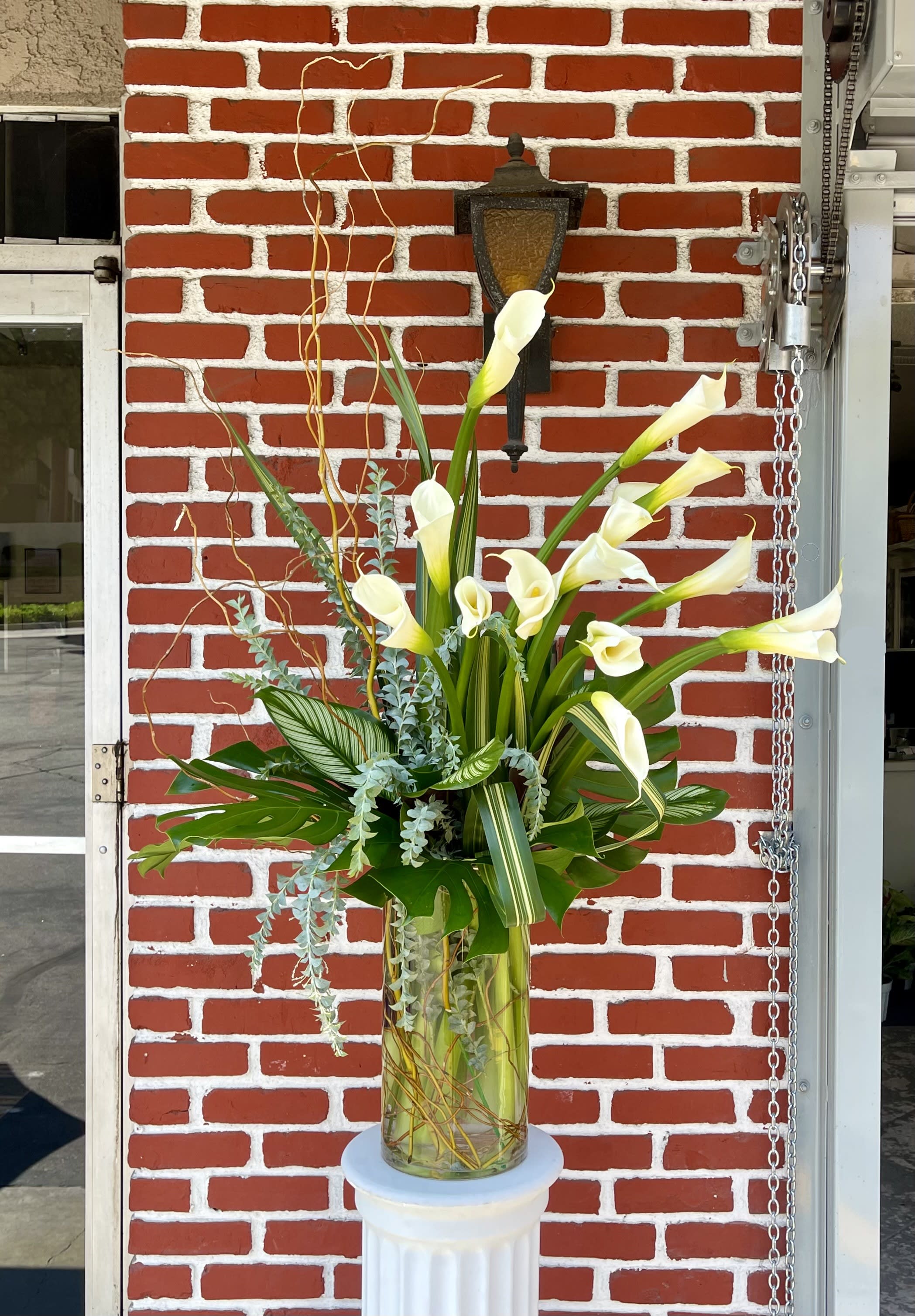 Calla Lilies Calla Lilies - A stunning arrangement of calla lilies, curly willow and greenery. Perfect for any occasion. We make our arrangements as fresh as possible, so certain flower colors and varieties may differ depending on seasonal availability.