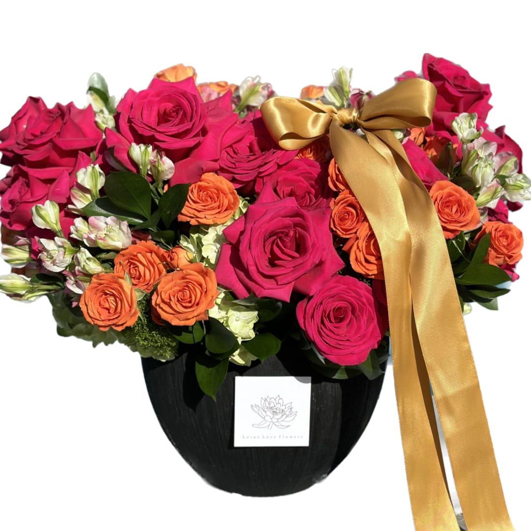 Lotus Love Bright Blooms  - A stunning arrangement crafted with meticulous care, where vibrant colors burst forth, infusing the air with a vibrant energy. This flower arrangement is a symphony of elegance and radiance, primarily revolved around the enchanting beauty of fresh blooms. This arrangement is tied with a satin ribbon or twine, adding a touch of refined sophistication to the ensemble. 