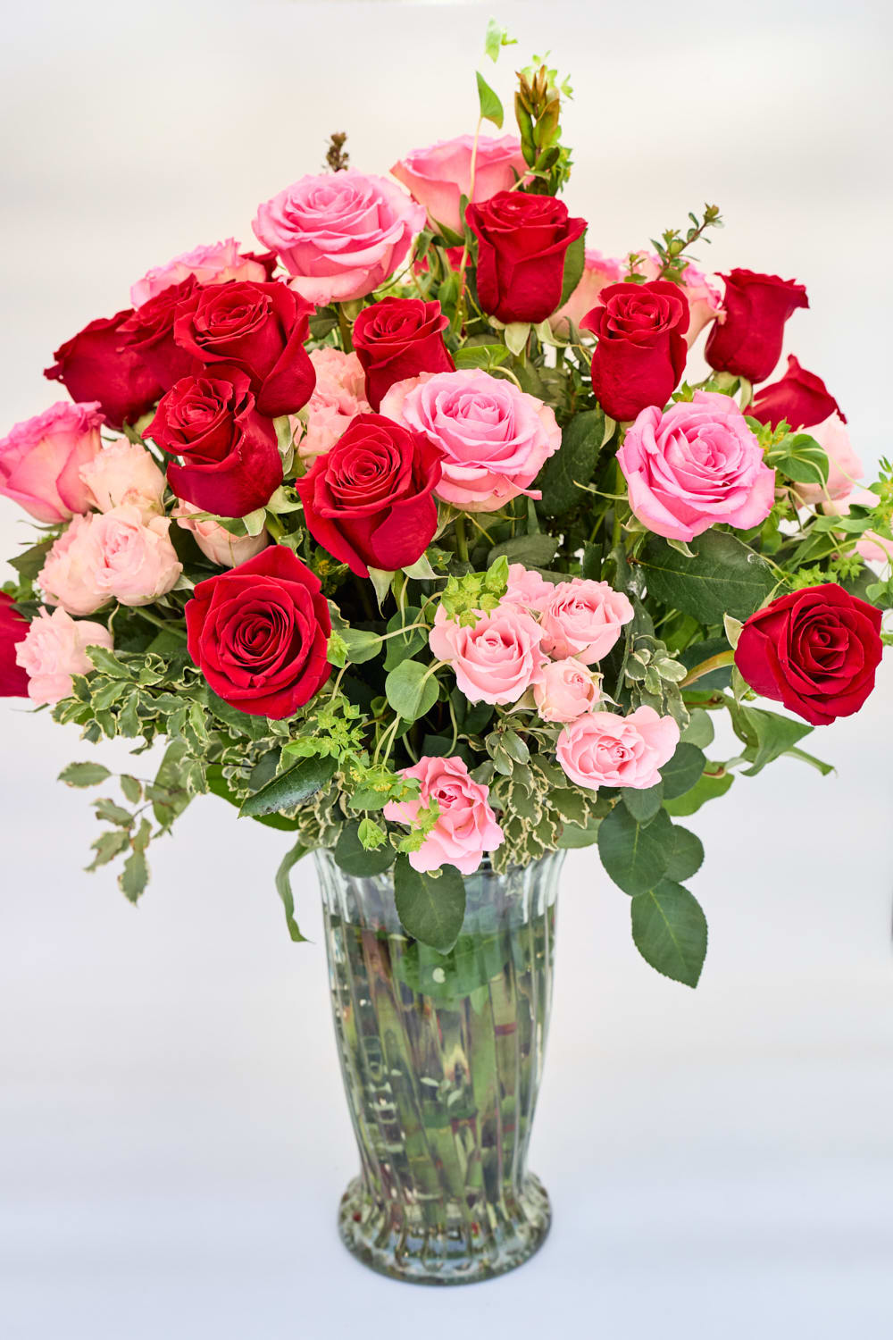 Roses Galore - Pink and Red Mix - Roses Galore!  A mix of two dozen pink and red roses accented with spray roses.  Because nothing says &quot;I Love You&quot; more than even more roses.  Bouquet includes one dozen red roses, one dozen pink roses, accented with pink spray roses and greenery. Arranged in a clear glass vase.