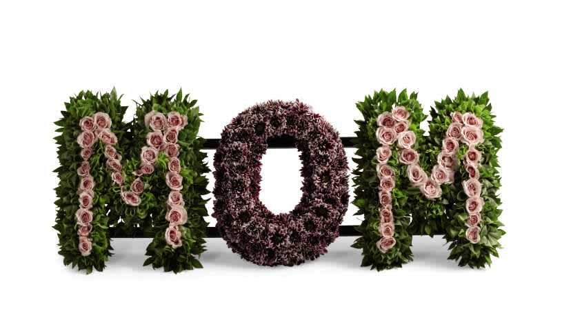 The FTD Remembering Mom Arrangement The FTD Remembering Mom Arrangement - The FTD Remembering Mom Arrangement honors the life and the love you have for your mother at her final farewell service. Light pink spray roses, plum daisy poms, Bells of Ireland, and myrtle stems are artfully arranged to spell the word, âMom,â creating a wonderful memorial for the woman who continues to shape your life's journey.