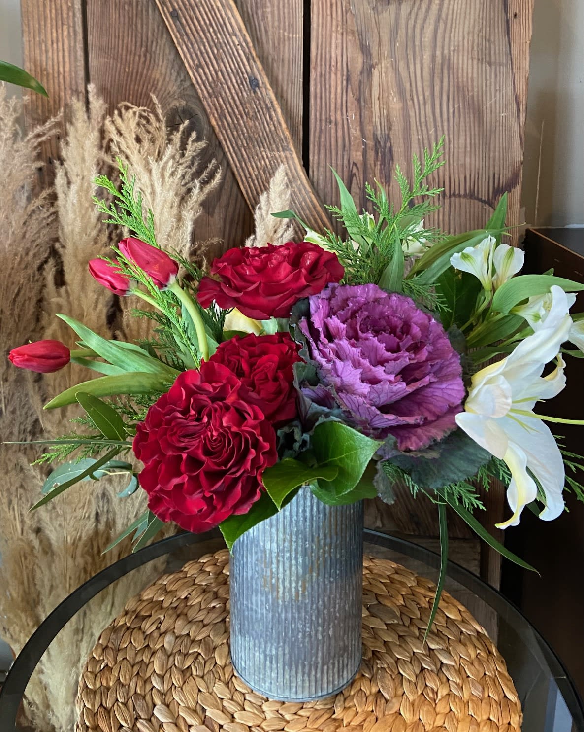 Cheer - Delightful Assortment of Seasonal Blooms Highlighted with Evergreens in a Keepsake Corrugated Metal Container.