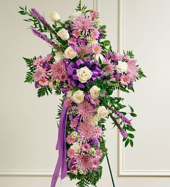 Peace and Prayers Standing Cross - Lavender - Product ID: 91196   Send a beautiful and moving floral tribute that shows your support and love during this difficult time. This standing spray arrangement â in the shape of a cross â is created from fresh flowers such as white roses and carnations, lavender daisy poms, and more. Traditionally sent directly to the funeral home by family members or friends and displayed on a stand. Our florists use only the freshest flowers available so varieties and colors may vary. Measures approximately 40&quot;H x 26&quot;L without easel.