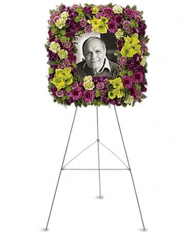 Mosaic of Memories Square Easel Wreath - A unique and lovely tribute for the service, this contemporary square easel wreath of purple and green flowers is a gift of caring expressed with beauty and style. The elegant arrangement includes purple alstroemeria, green gladioli, green carnations, purple cushion spray chrysanthemums, lavender button spray chrysanthemums, green button spray chrysanthemums and purple button spray chrysanthemums, accented with assorted greenery.