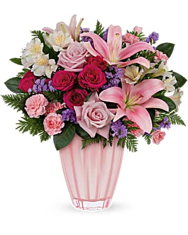 Teleflora's Dancing Beauty Bouquet - Dance into Mother's Day with this beautiful ballet pink surprise! Feminine roses and lilies brighten her special day in a keepsake vase of European glass with metallic finish. Pink roses, hot pink spray roses, white alstroemeria, pink asiatic lilies, miniature pink carnations and lavender sinuata statice are arranged with leatherleaf fern. Delivered in a Dancing Beauty vase.