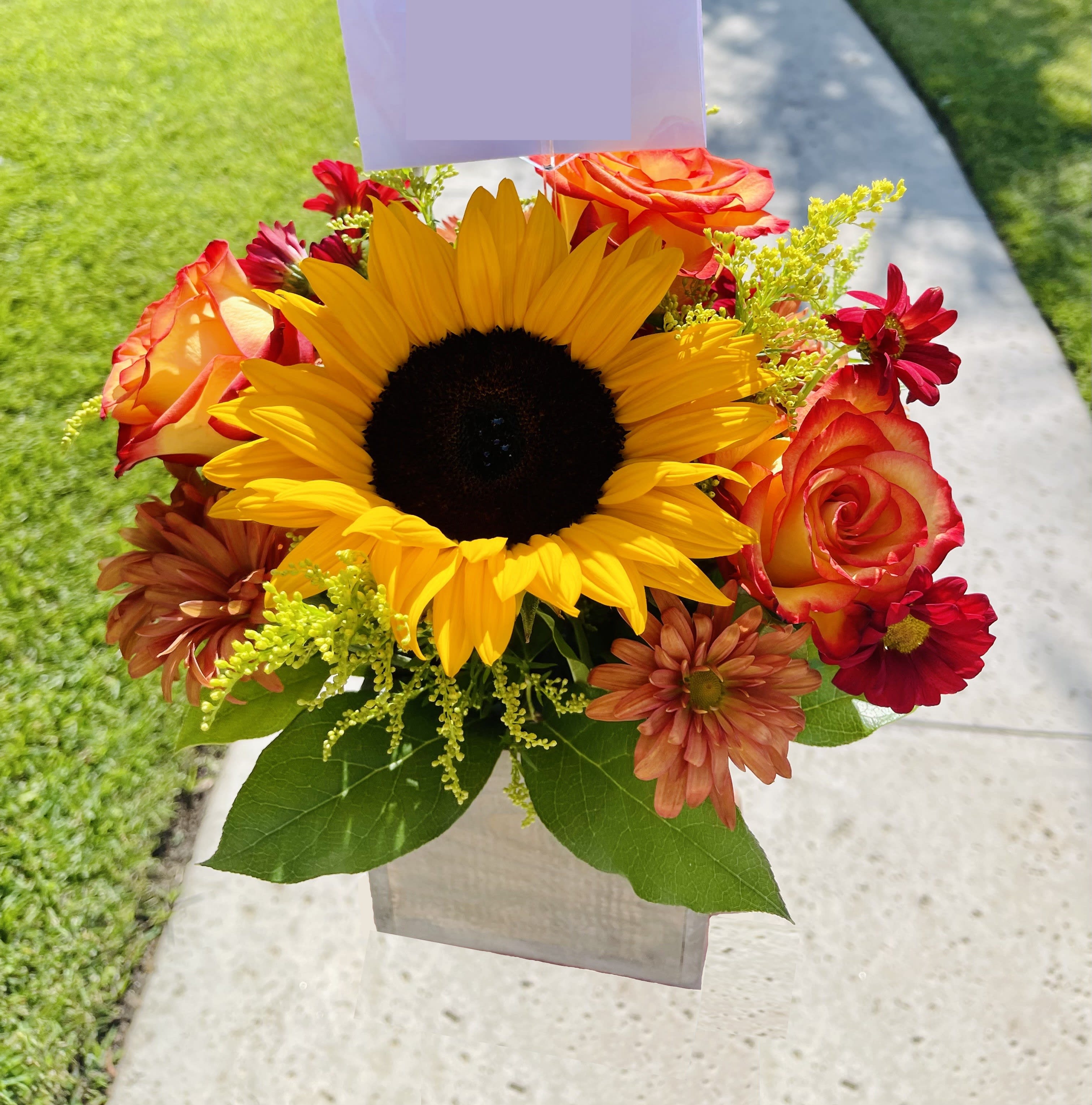 Fall Harvest - A glowing, autumn arrangement including a sunflower surrounded with orange roses, rusty red and orange daisies, accented with solidago and greenery in a wooden box.  Our florists hand-design each arrangement, so colors and varieties may vary due to availability. 