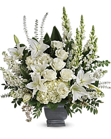 True Horizon Bouquet - As hopeful as the bright horizon ahead, this glorious white bouquet of hydrangea, roses, lilies and snapdragons is a peaceful tribute to a truly beloved. White hydrangea, white roses, white oriental lilies, white snapdragons, and white stock are arranged with huckleberry, seeded eucalyptus, spiral eucalyptus, green ti leaves, and lemon leaf. Delivered in Teleflora's Modern Heritage Pot. Orientation: One-Sided