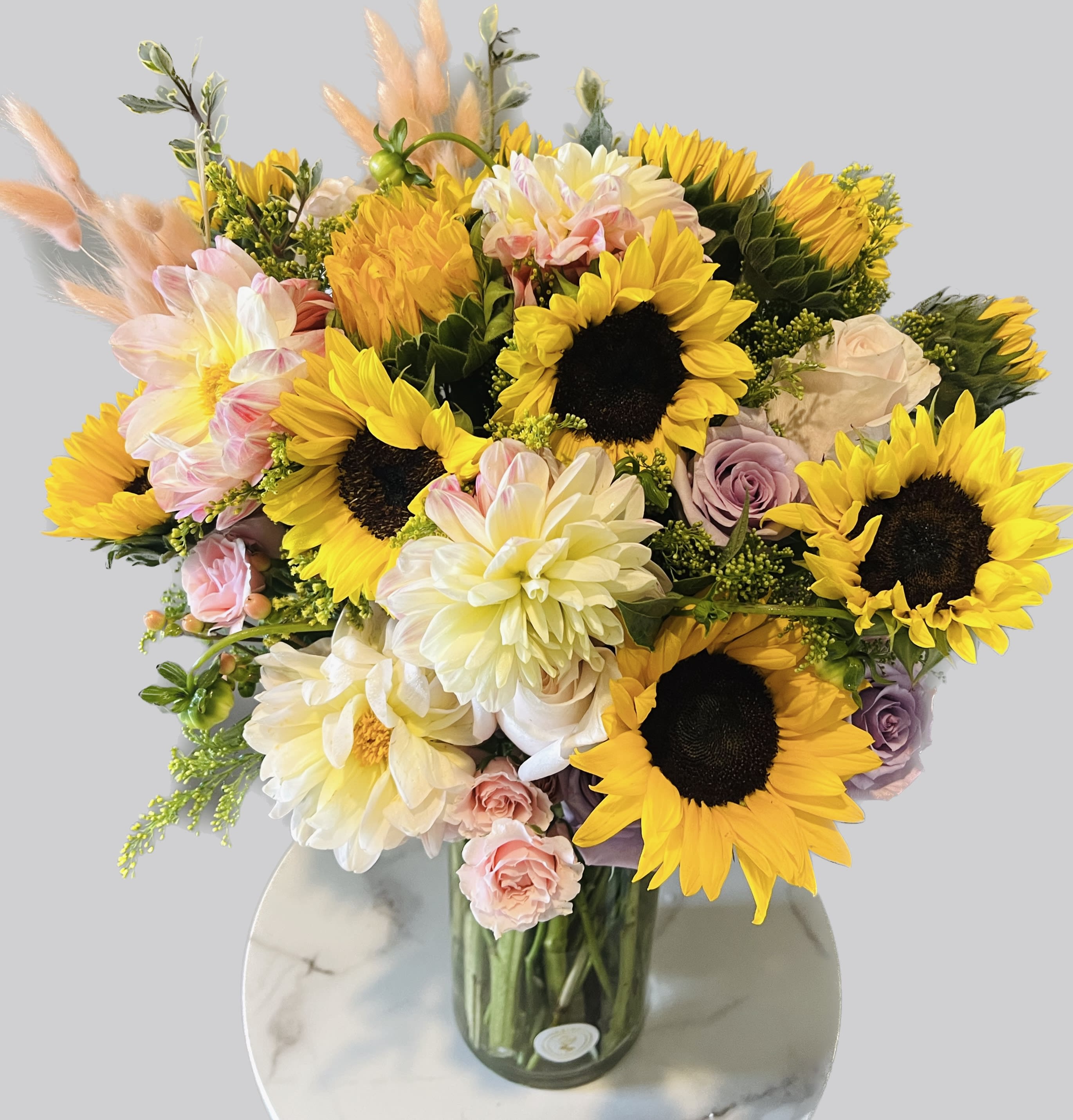 Sunny pretty flowers - This arrangement includes  sunflowers ,roses and seasonal blooms It is the perfect gift for a Birthday, Thank You, or Just Because