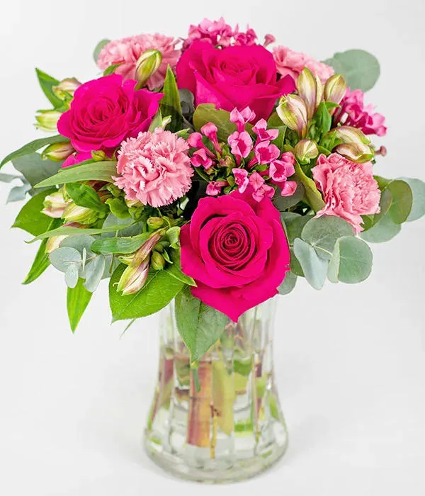Blush Bouquet Blush Bouquet - Bold cerise roses are the focal point of this bouquet, surrounded by carnations, alstroemeria, bouvardia and mixed foliage to complement.