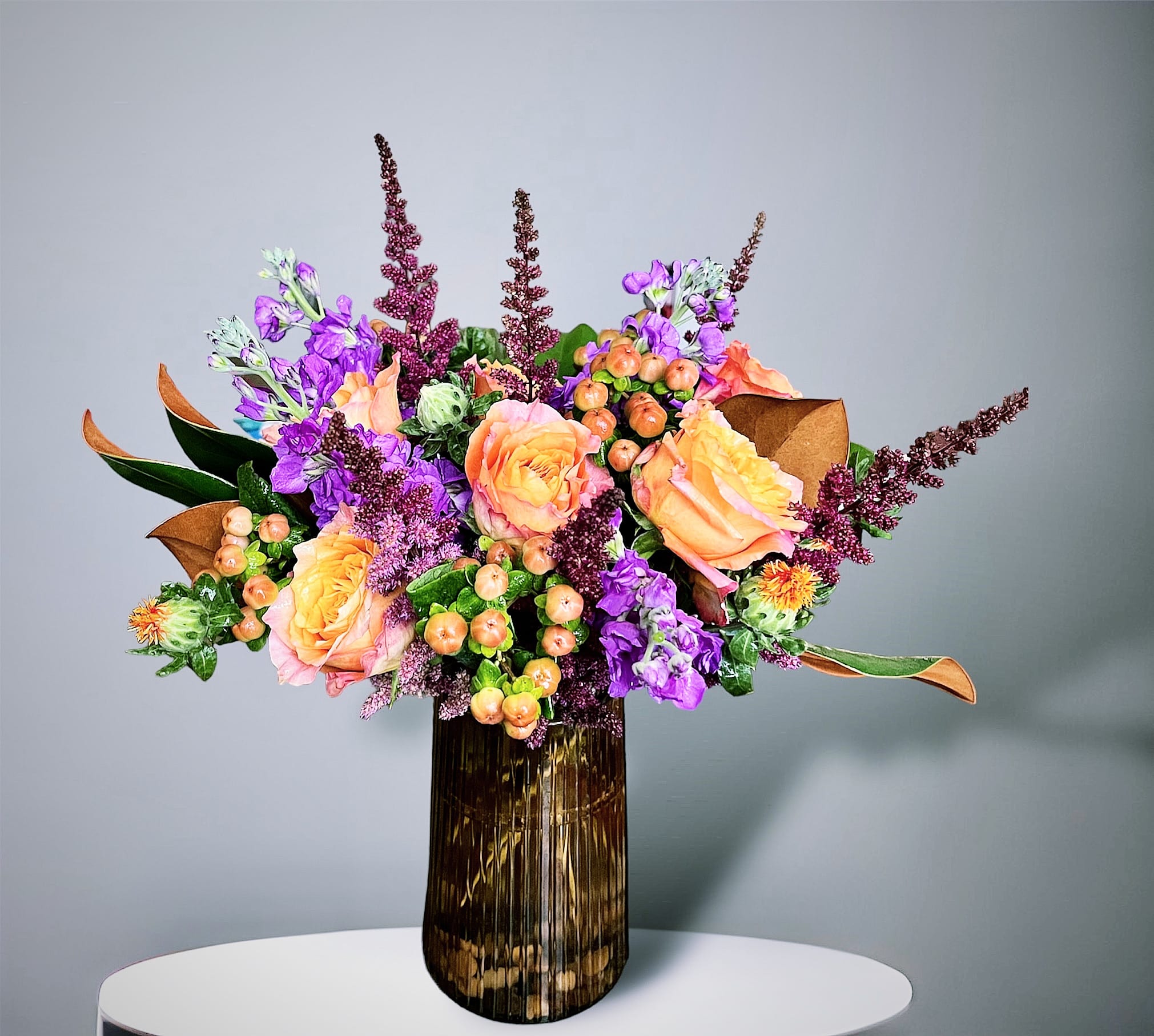 Elegant Fall Elegant Fall - A beautiful Fall arrangement featuring roses, stock, berries, and other seasonal accents in an elegant champagne glass vase.