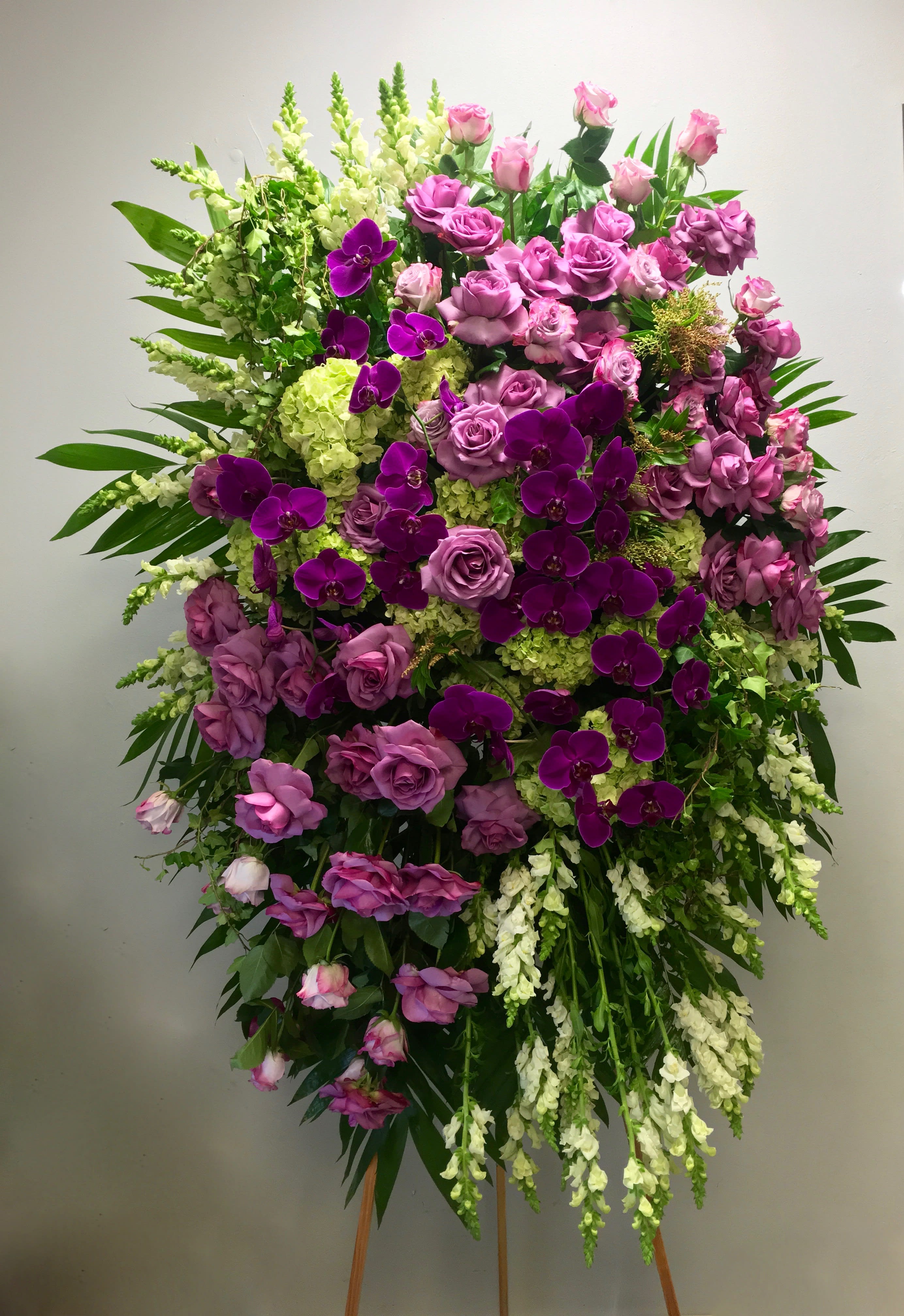 Purple Orchid Spray  - This sympathy spray contains roses, orchids, hydrangeas, and seasonal greens.    We include easel, printed banner and delivery (some fees may apply).  Standard size is 30'' wide, deluxe is 36'', and premium is 42''.