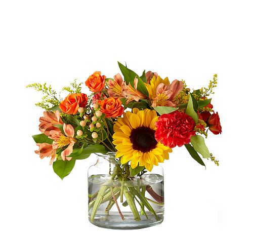 Sunnycrisp Bouquet - Take a morning stroll through a buzzing garden with the Sunnycrisp bouquet that simply beams with happy blooms. Watch sunflowers follow the light around the ruby carnations, all tied together with adorable hypericum berry stems.