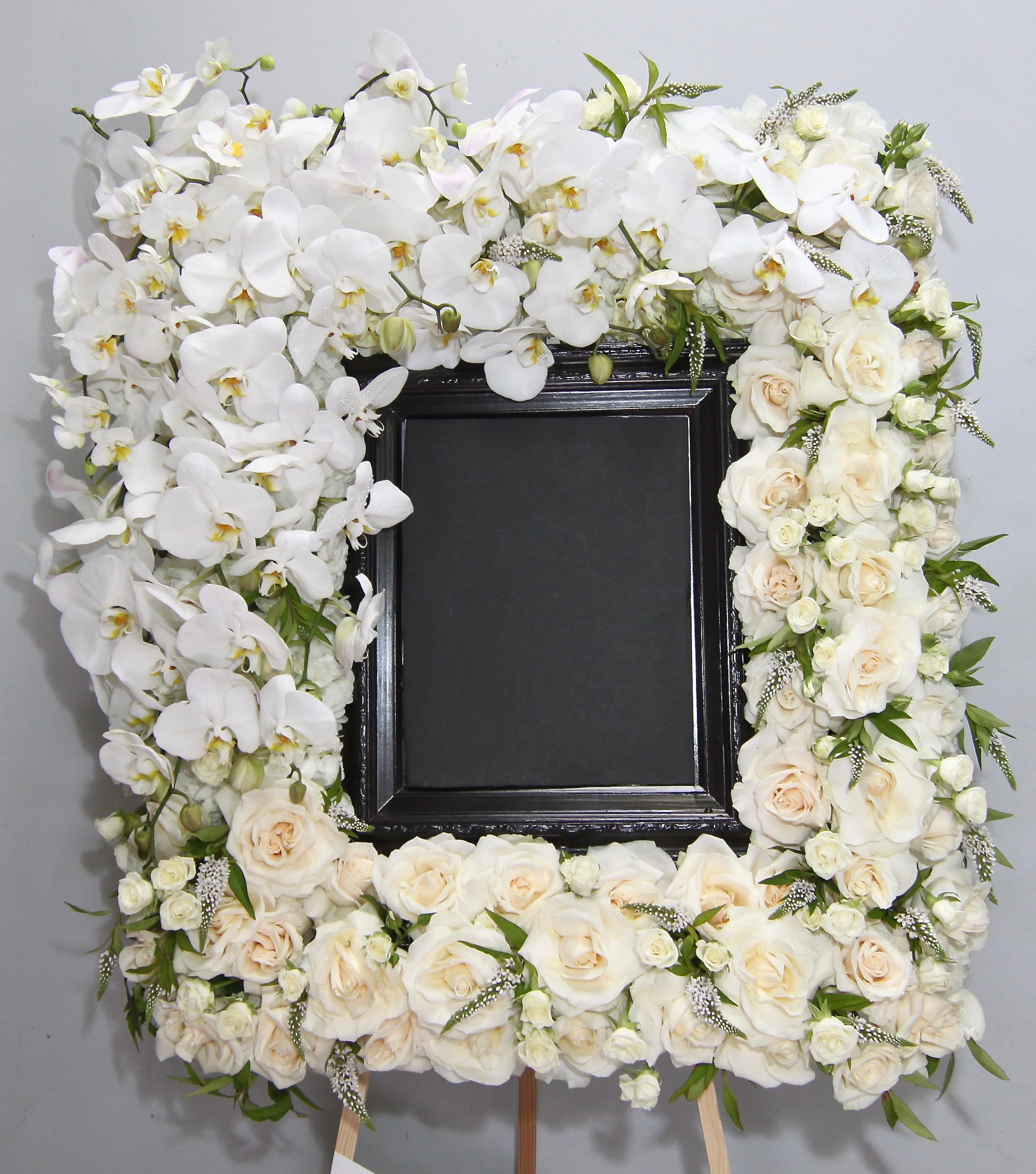 Orchid and Veronica Frame  - Standing at approximately 32inches, this frame contains white orchids, roses, and white veronica. Actual photo frame not included. Please provide this for us to place in the arrangement. Call to coordinate.   Large frame dimensions approximately 36x28  