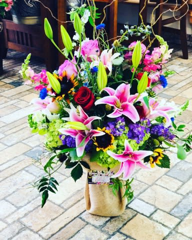 Rainbow Wishes - When you truly want to spoil your significant other and brighten their day, send this extravagant arrangement! Head turner and dramatic, this mix of lilies and roses, sunflowers and lavish greens brings all the colors of the rainbow!