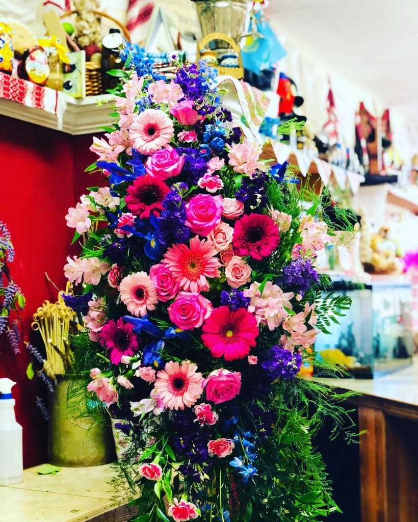 Divine Daisy Tribute Standing Spray Divine Daisy Tribute Standing Spray - Standing Spray is a rich and colorful way to express your unending love and devotion to the departed. An exceptional arrangement of gerbera daisies, assorted flowers, and accented with a variety of lush greens.