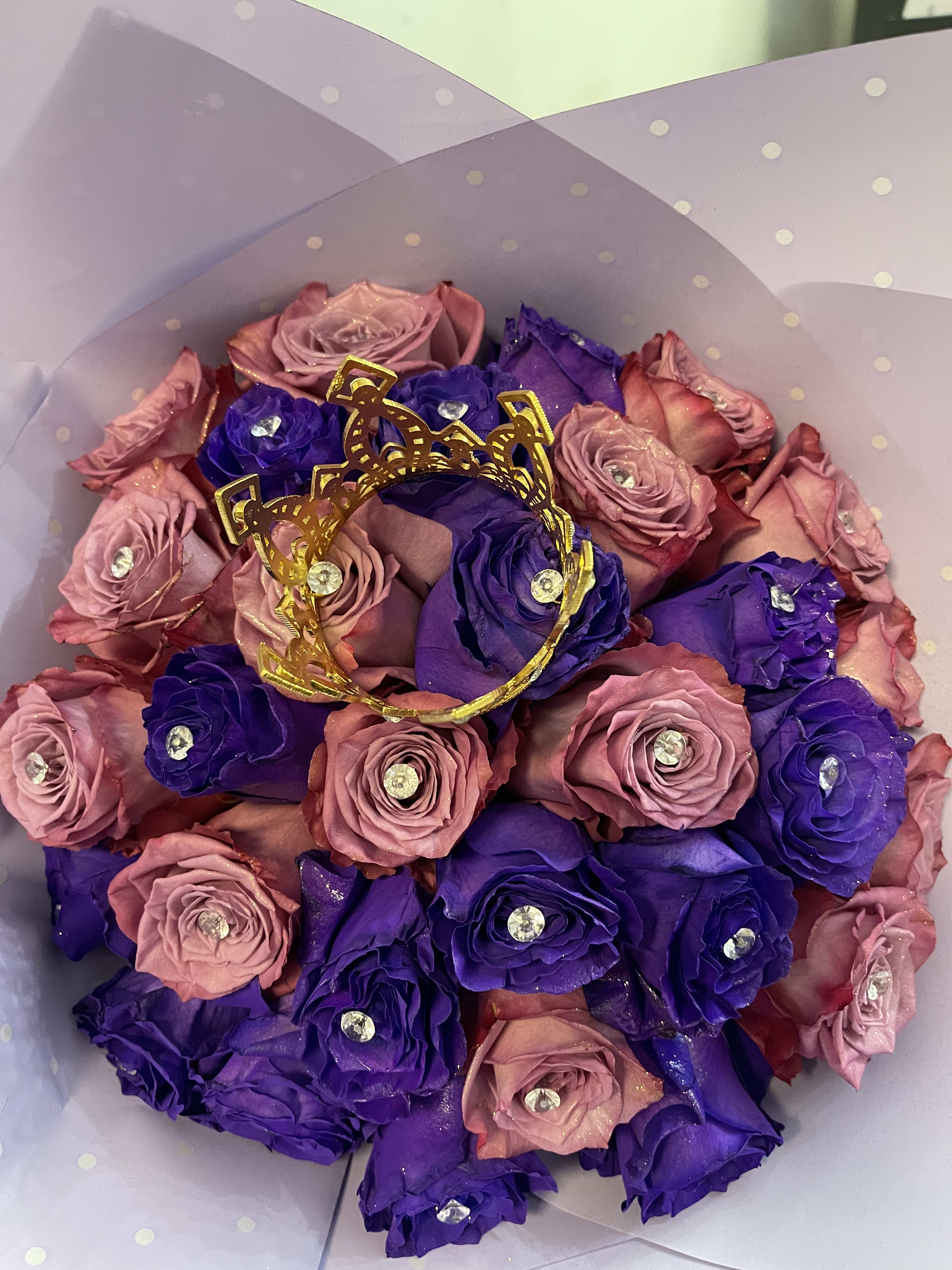The double purple queen bling ramo bouchon - This is a beautiful bouquet made with 2 different tones of purple roses. This bouquet has 30 roses and every rose has a diamond and a crown is placed in the center giving it that luxury style 
