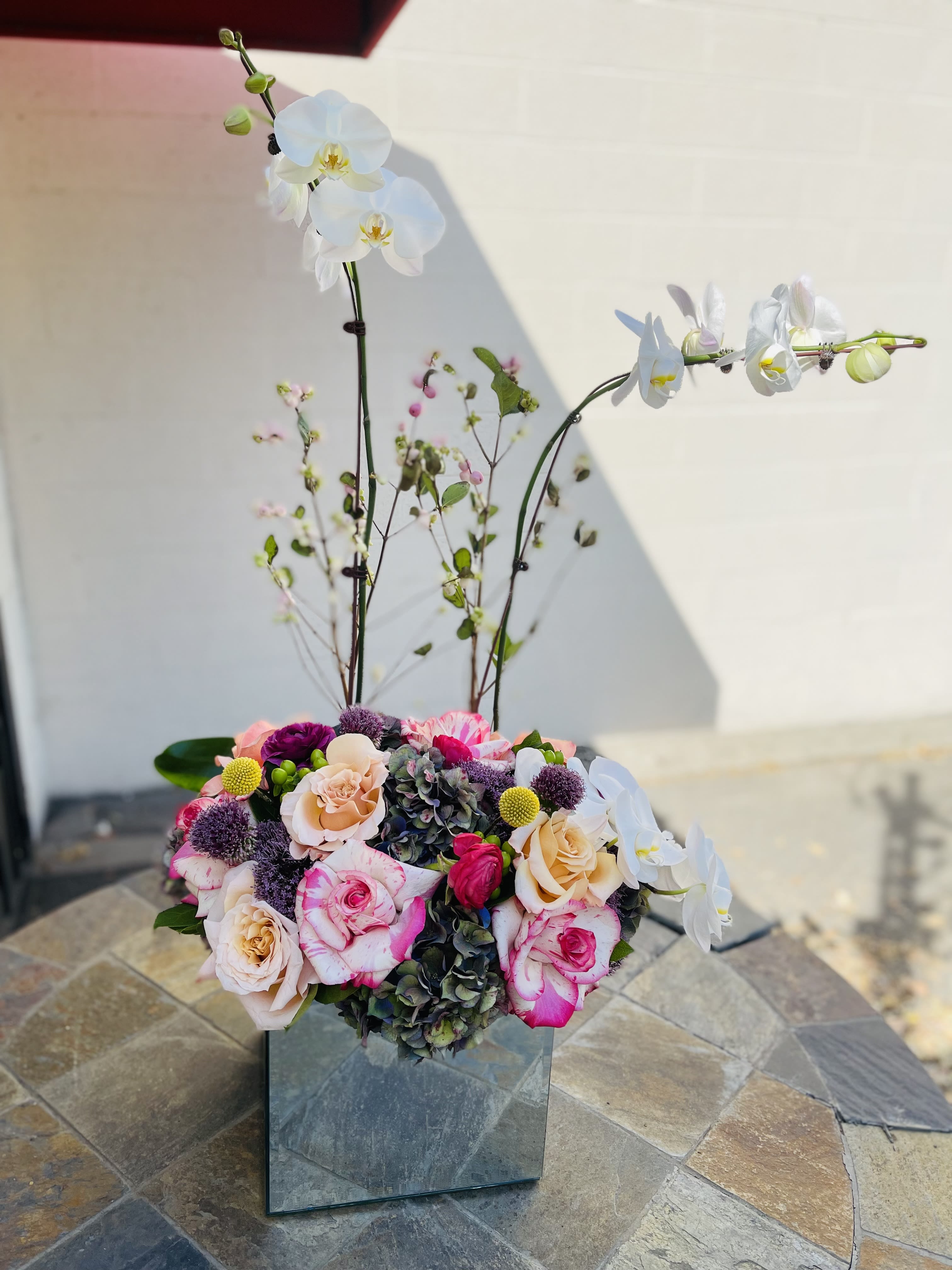Two large Orchids with lushes European flowers  - Two large beautiful large orchid plants with garden flowers surrounded at the bottom. 