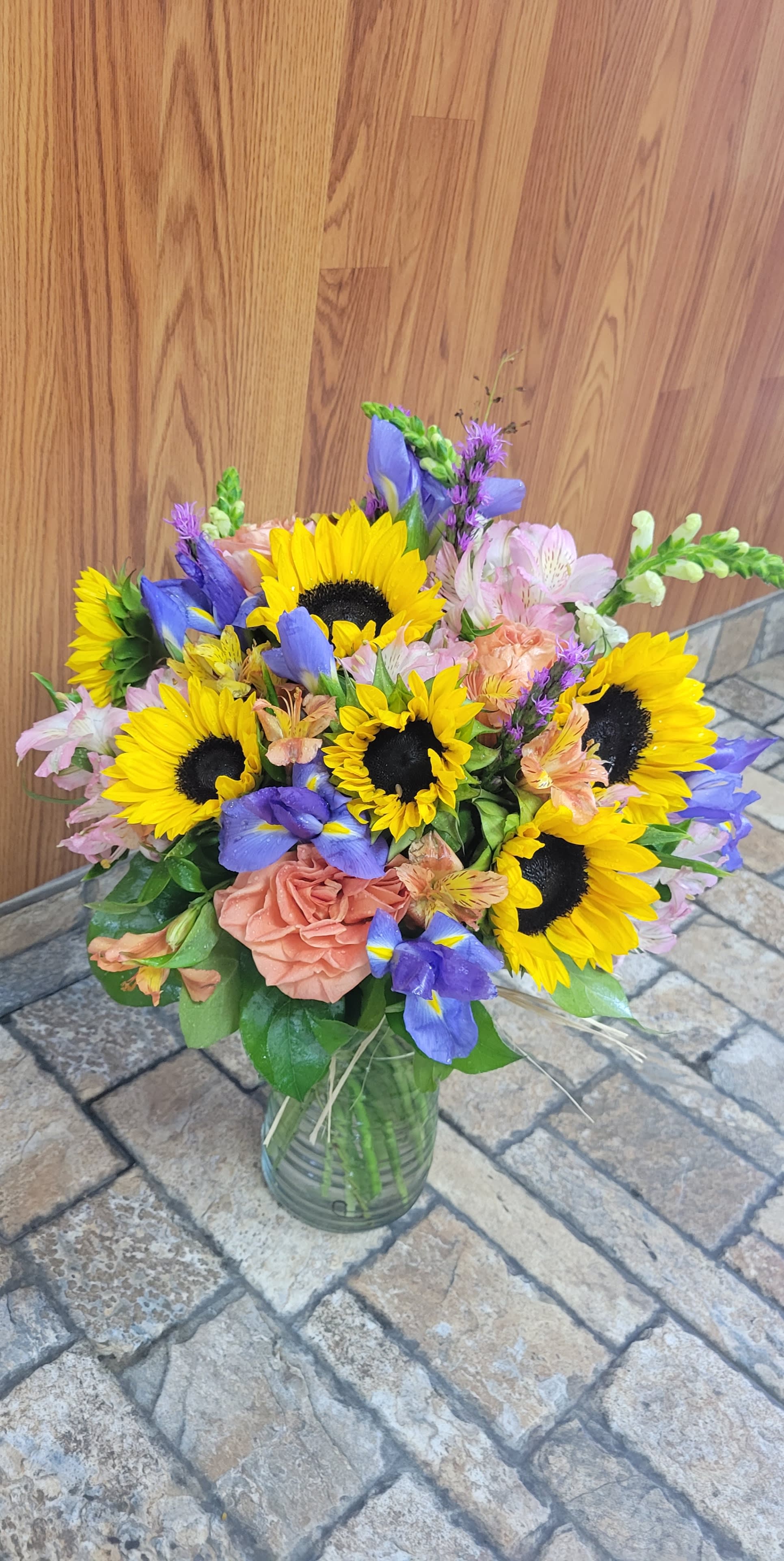 Pretty Portrait - A picturesque mix of sunflowers, snapdragons, iris, roses, alstroemeria, and fresh greenery. A thoughtful statement for that picture perfect person in your life. 