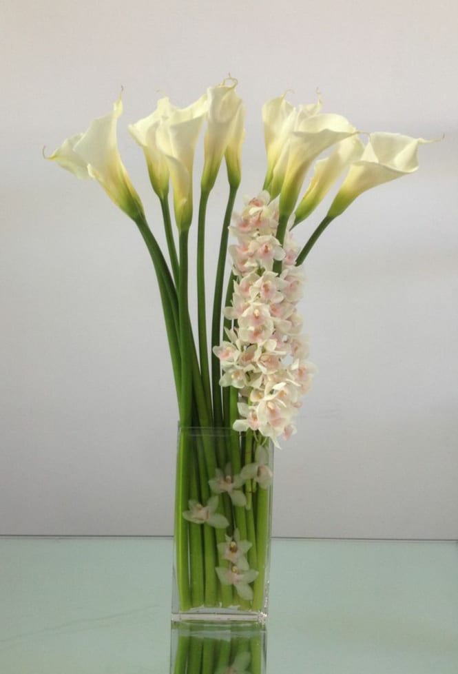 Elegant Bliss - Calla lilies and orchids combine to create a tall and striking piece that's sure to impress.