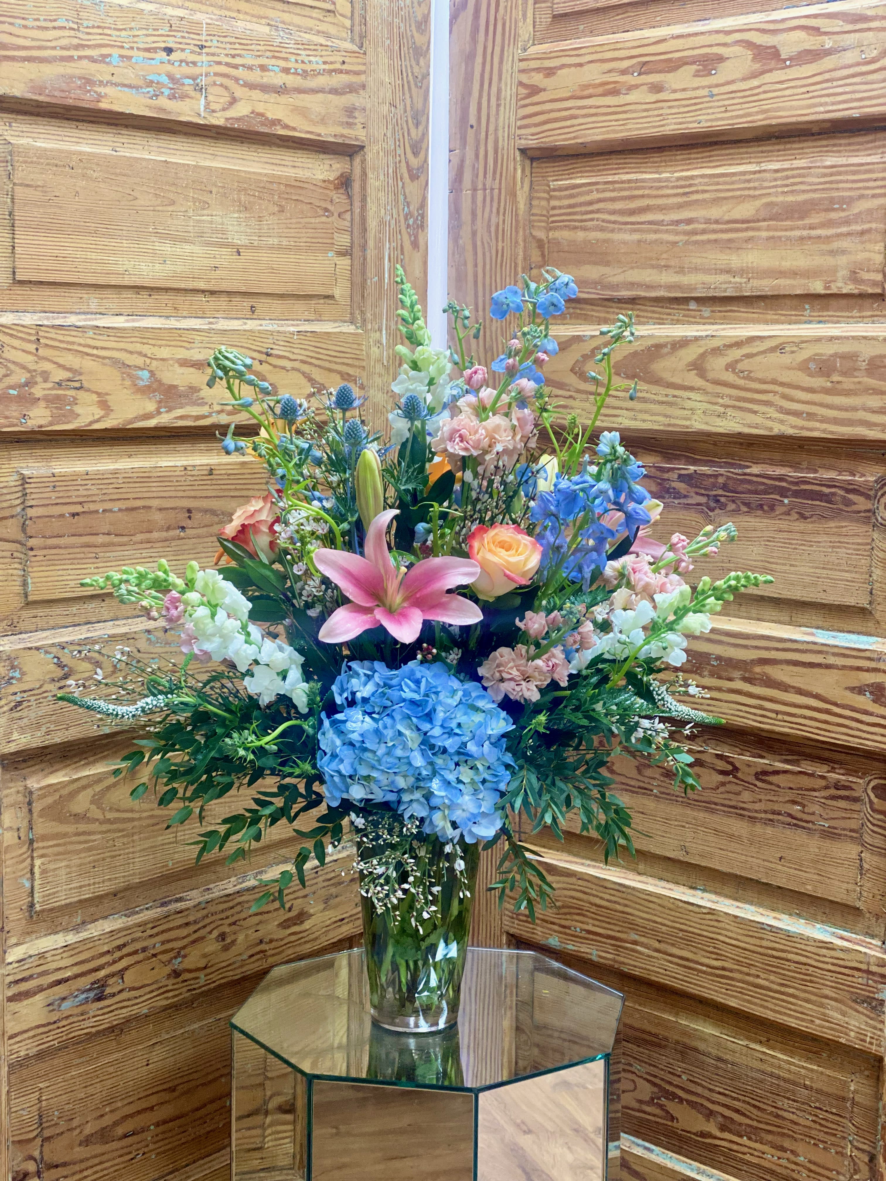 The Donna - Beautiful arrangement featuring hydrangea, delphinium, snap dragons, roses, lillies and more!