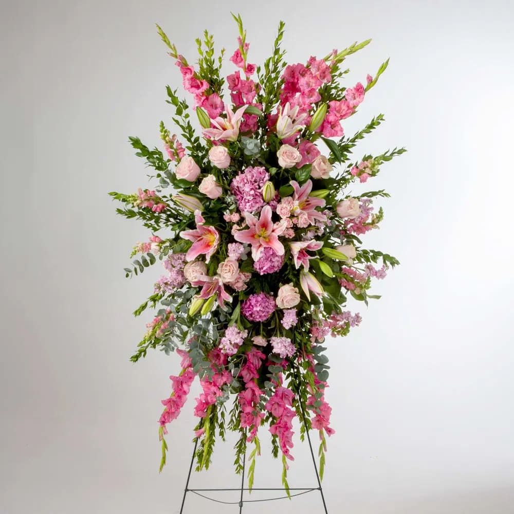Compassion by BloomNation™  - Pink roses, lilies, and more come together for a blushing pink standing funeral spray.  Optional Banner included upon request.   Include your banner message in the Florist Instructions during checkout, or give us a call at (562)692-0438.