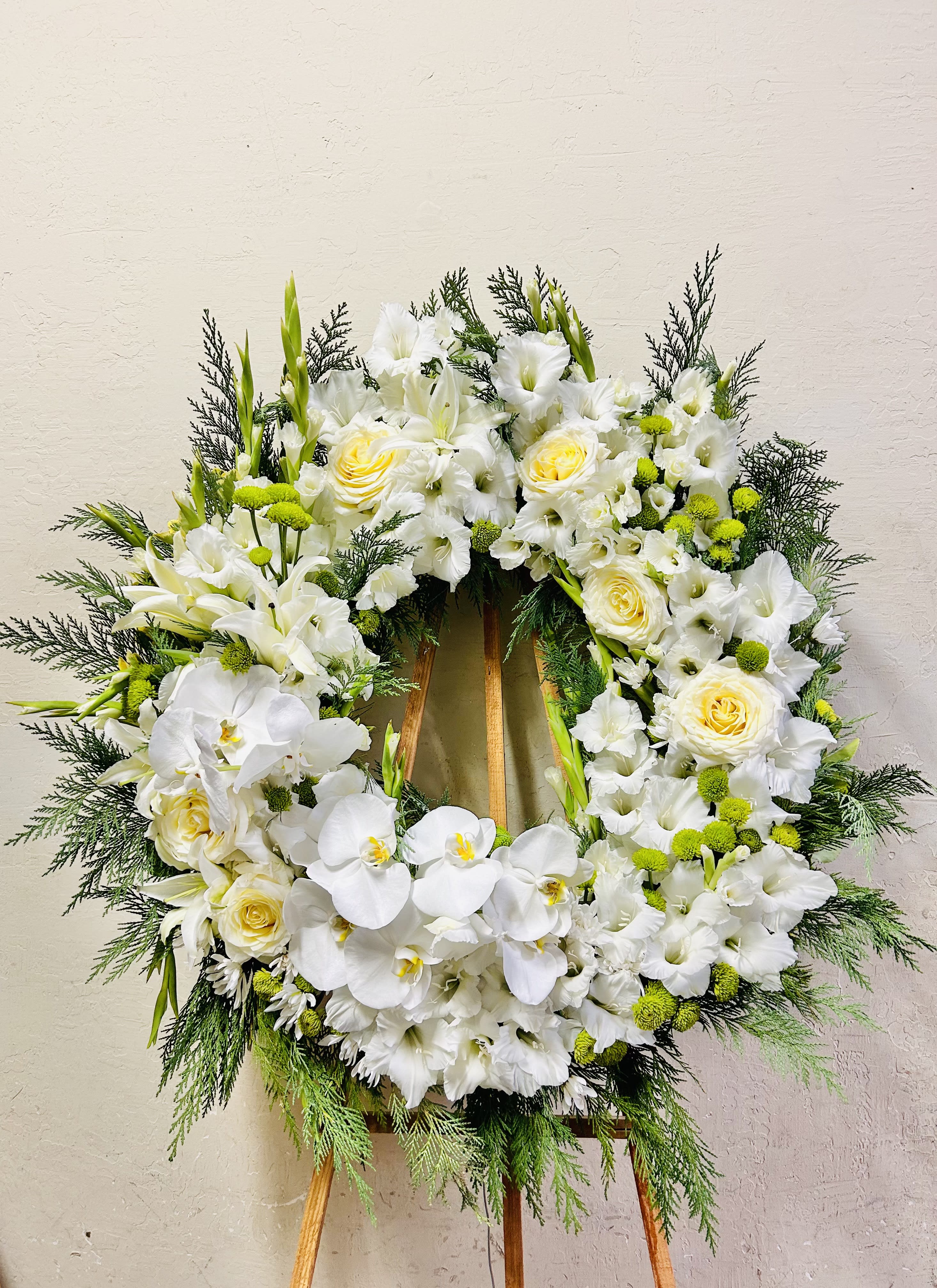 Serenity Blooms - Beautiful standing funeral spray featuring white roses, gladiolus, orchids, and green accents.