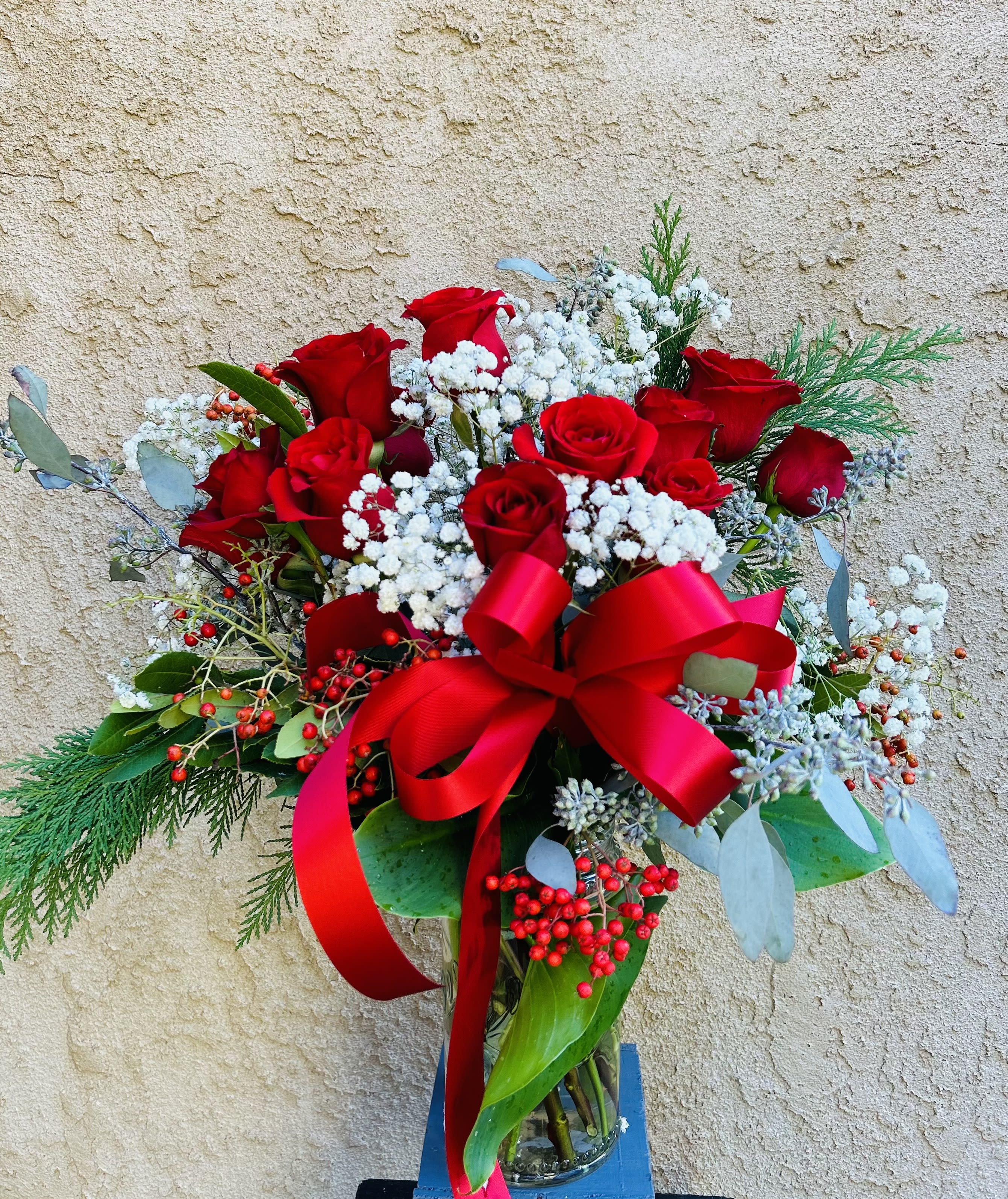 Life in Bloom - Beautiful arrangment featuring red roses, white baby breathe and green accents.
