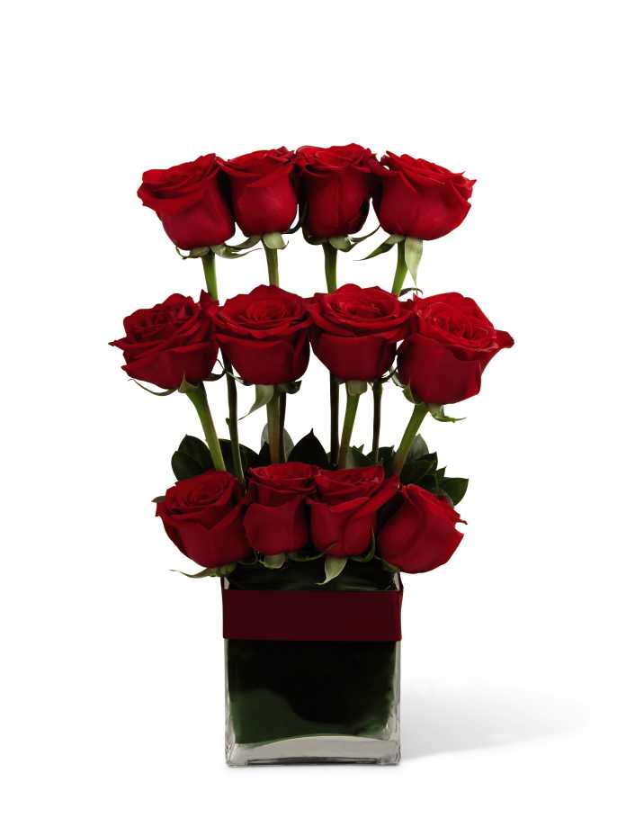 The FTD Towering Beauty Arrangement - The FTD Towering Beauty Arrangement is a charming way to express your love and unending affection for the deceased or for those suffering from a loss. Rich red roses are artfully arranged in a cascading pattern to create a tower of beauty, offset by lush tropical greens and seated in a clear glass cube vase accented with red satin ribbon, creating a symbol of perfect beauty to convey your sentiments of warmth and comfort.