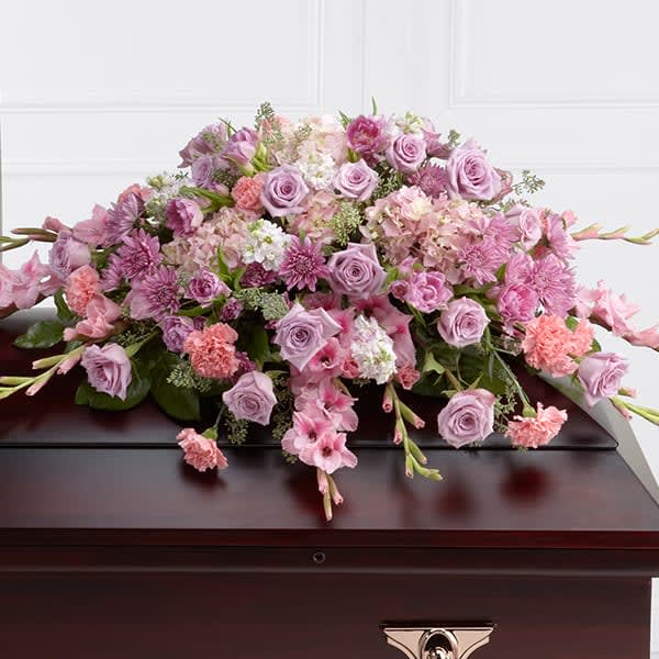 The FTD Immorata Casket Spray - The FTD® Immorata™ Casket Spray offers soft beauty and blushing comfort to honor the life of the deceased. Lavender roses chrysanthemums and parrot tulips are elegantly arranged amongst pink carnations gladiolus stock hydrangea and lush greens to create a presentation intended to bedeck the top of the casket that evokes sweet memories of your loved one for their final farewell service.