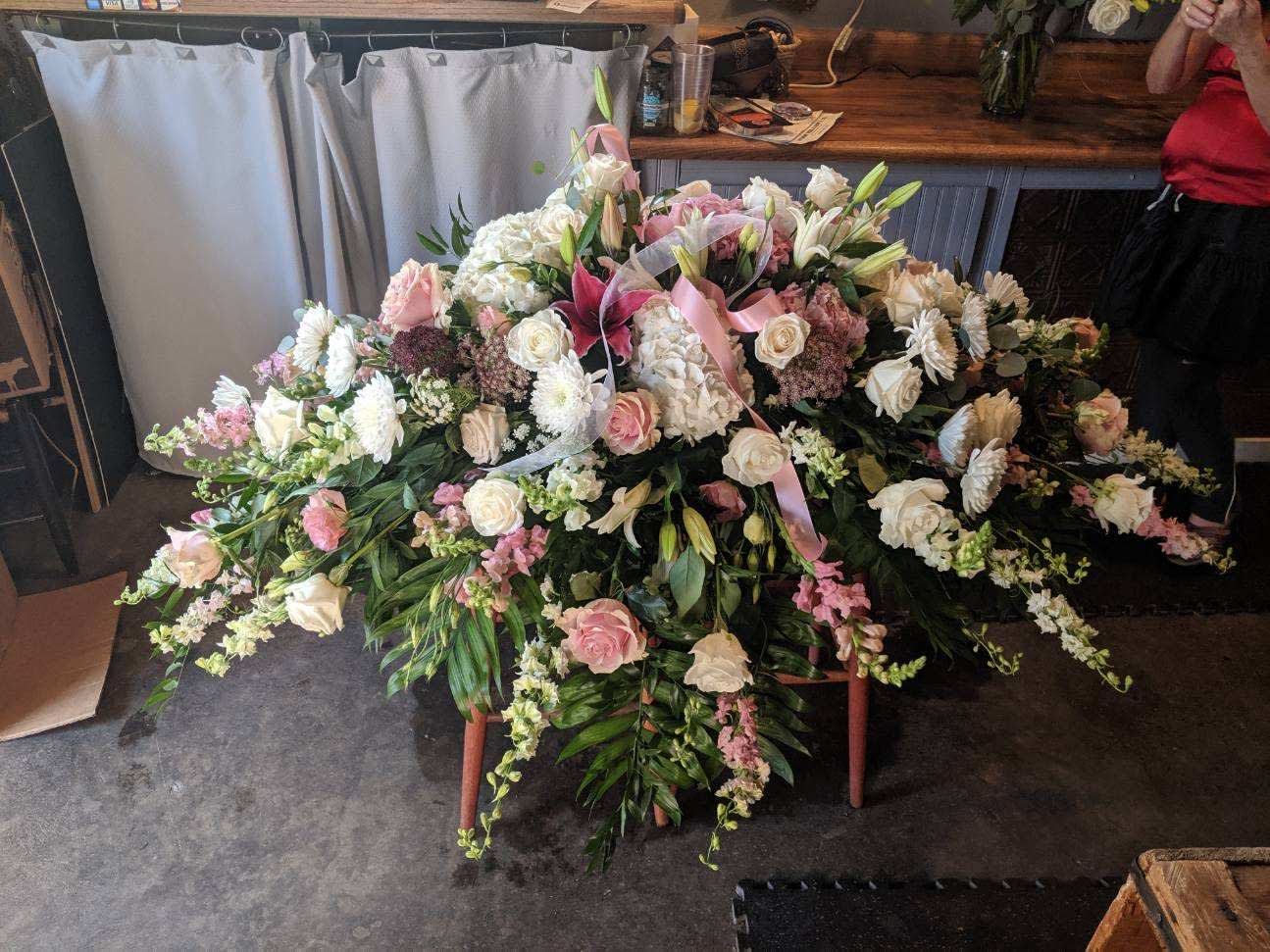 Pink and White Casket Spray Pink and White Casket Spray - An abundance of pink and white roses will express your love and devotion with beauty. This classic casket spray of roses mixed with choice pink and white blooms surrounded in lush greenery will be a fragrant reminder on a solemn day.