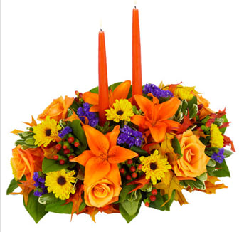 Give Thanks &amp; Praises - Whether it's welcoming in the Fall season or wishing everyone a Happy Thanksgiving, this centerpiece is right at home. Orange Asiatic lilies, Viking poms, orange roses, red hypericum and purple statice are combined in a lovely dish container with two elegant candles.