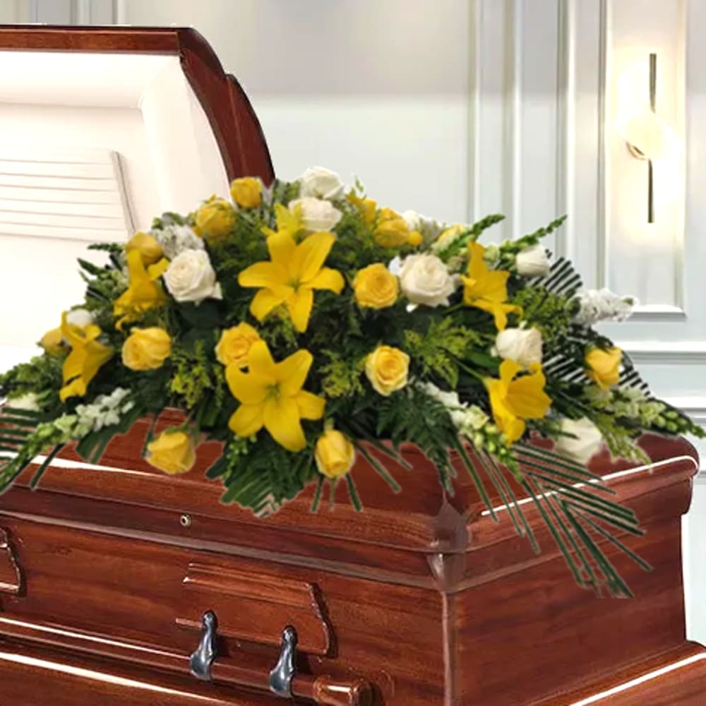 Yellow and White Casket Spray - Beautiful casket spray with yellow and white roses, lilies, accent blooms to match and lush greens. 
