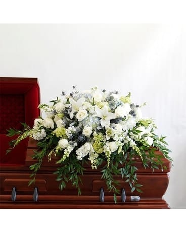 Tranquility Casket Spray - This incredible casket spray from the Tranquility Collection are lush with fragrant white lilies and stock, snapdragons, roses, orchids and white hydrangea, ruscus and lemon leaf foliage.  Half Casket $375, call to order