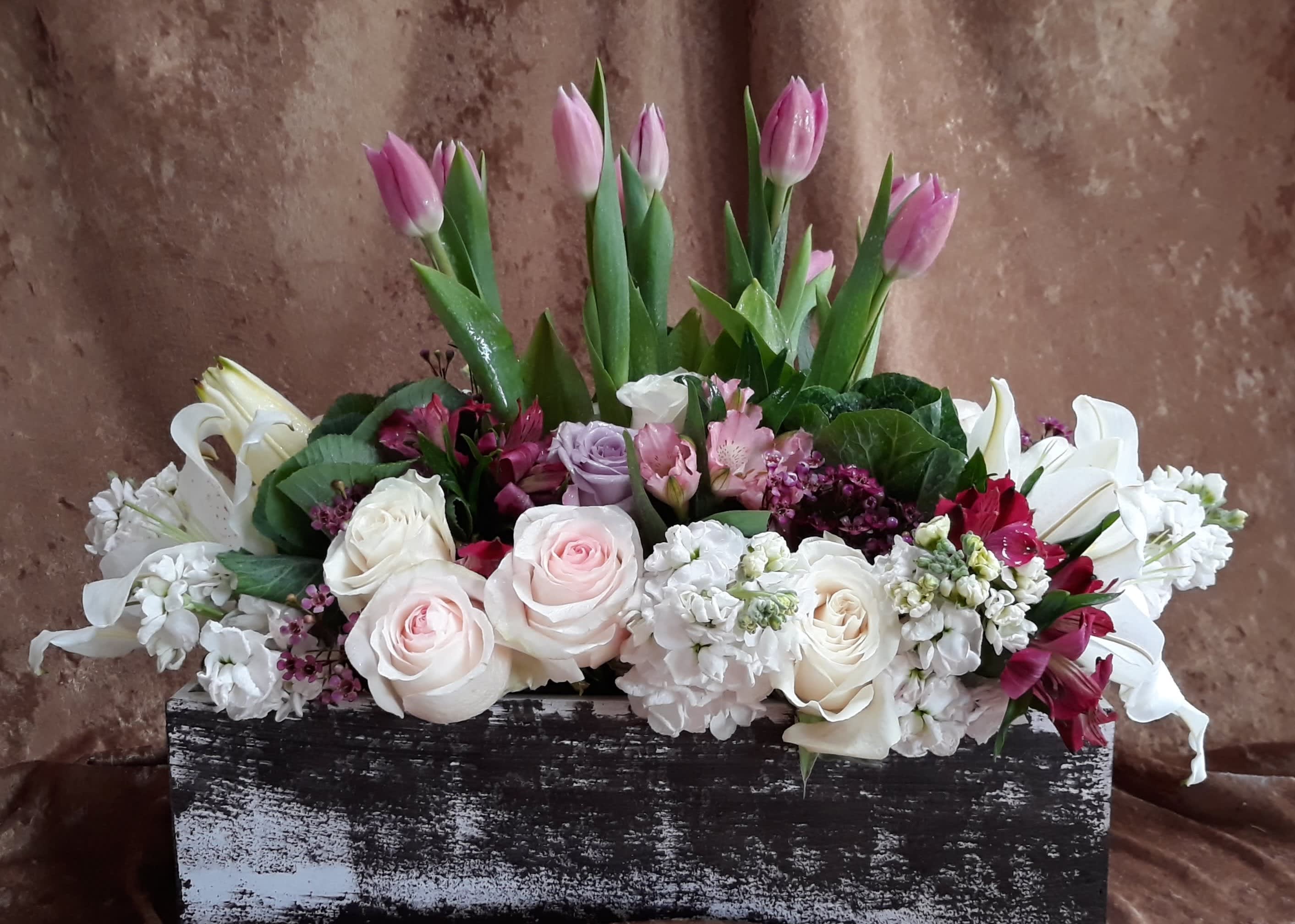 My Purple Tulips - SHOWN: DELUXE  14Wx16H  A nice arrangement including purple tulips, roses, lilies, stock flowers and seasonal blooms presented in a contemporary visual.