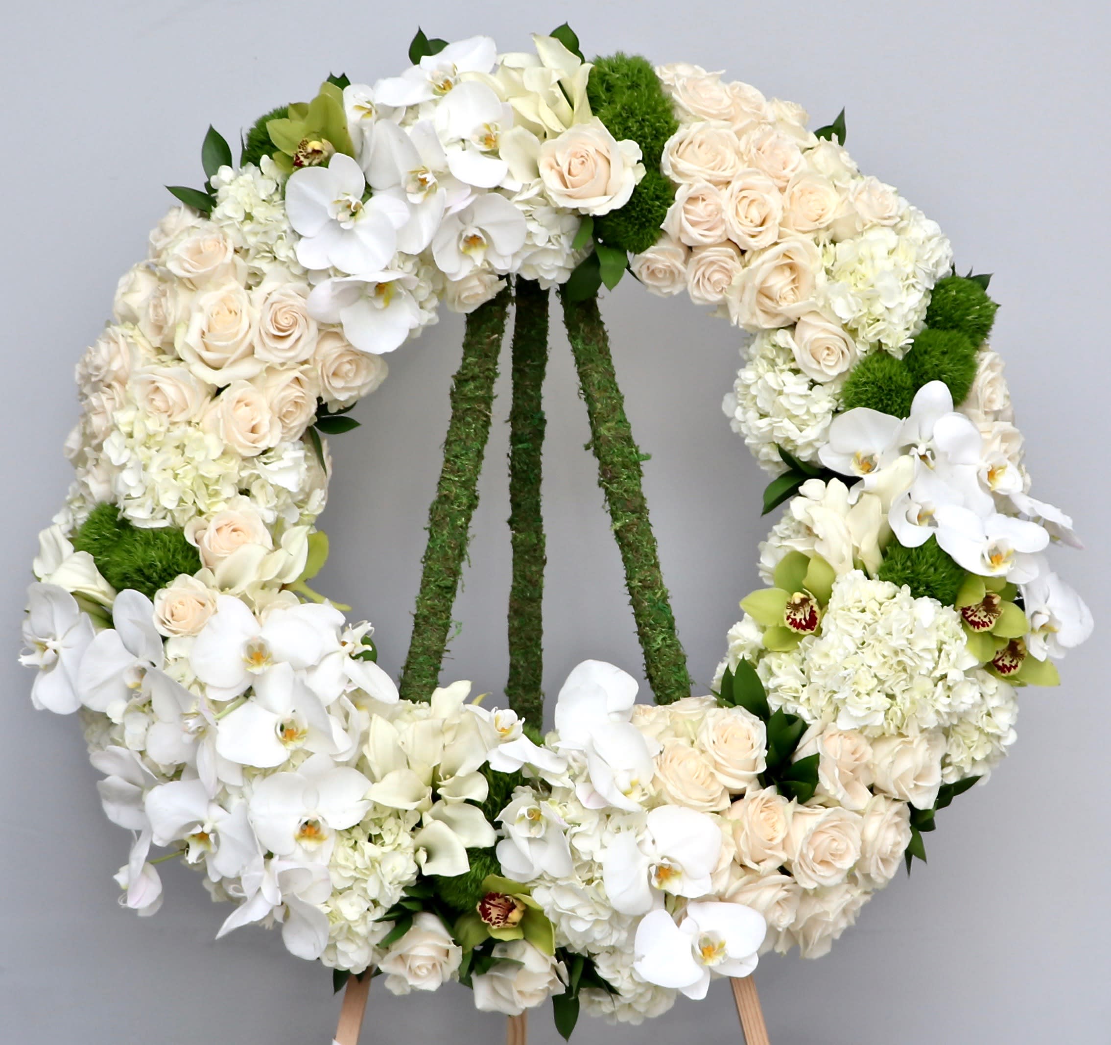 Orchids and Butterflies Wreath  - This wreath contains a mix of white orchids, hydrangeas and seasonal greens.   We include easel, printed banner and delivery (some fees may apply).  Standard size is 30'', deluxe is 36'', and premium is 42''.