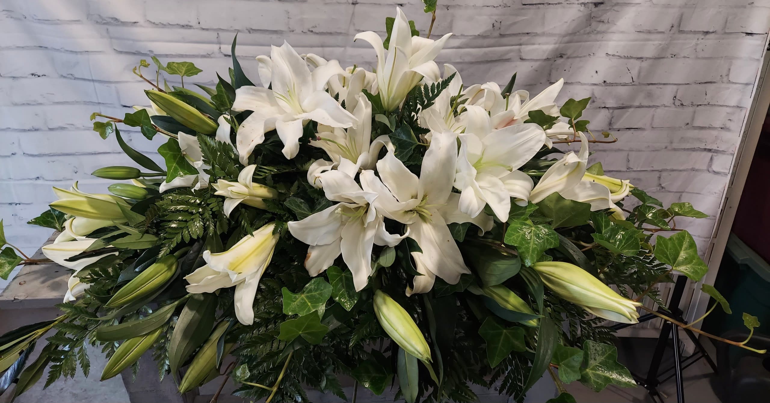 Light and Lilies Light and Lilies - This all white lily presentation is spectacular against the dark green contrast of the greens. A delicate but bold bloom to offer hope, peace and light.