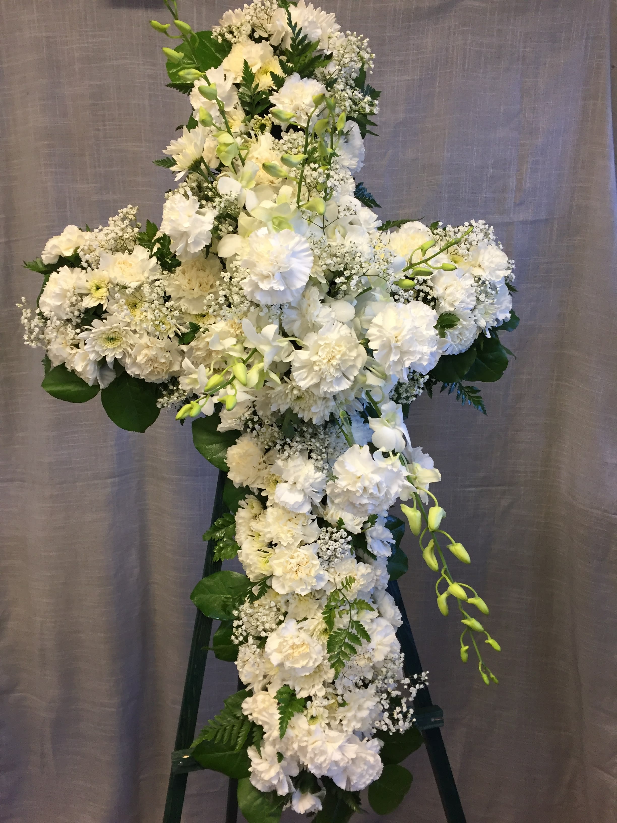 Standing White Cross - Pictured as a white spray against a white cross. The color of the accent flower spray can be customized. Please make a note in the special instructions. 