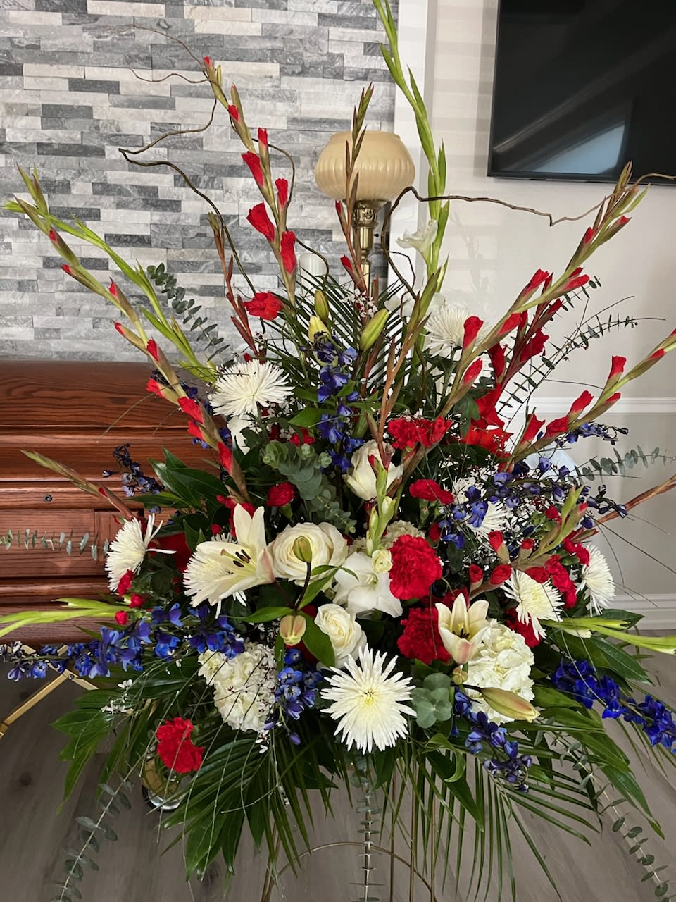 Red White &amp; Blue Large Arrangement - A mache type container with an assortment of the best available varieties of flowers in Red White and Blue. Stands about 3ft tall and 3ft wide. 